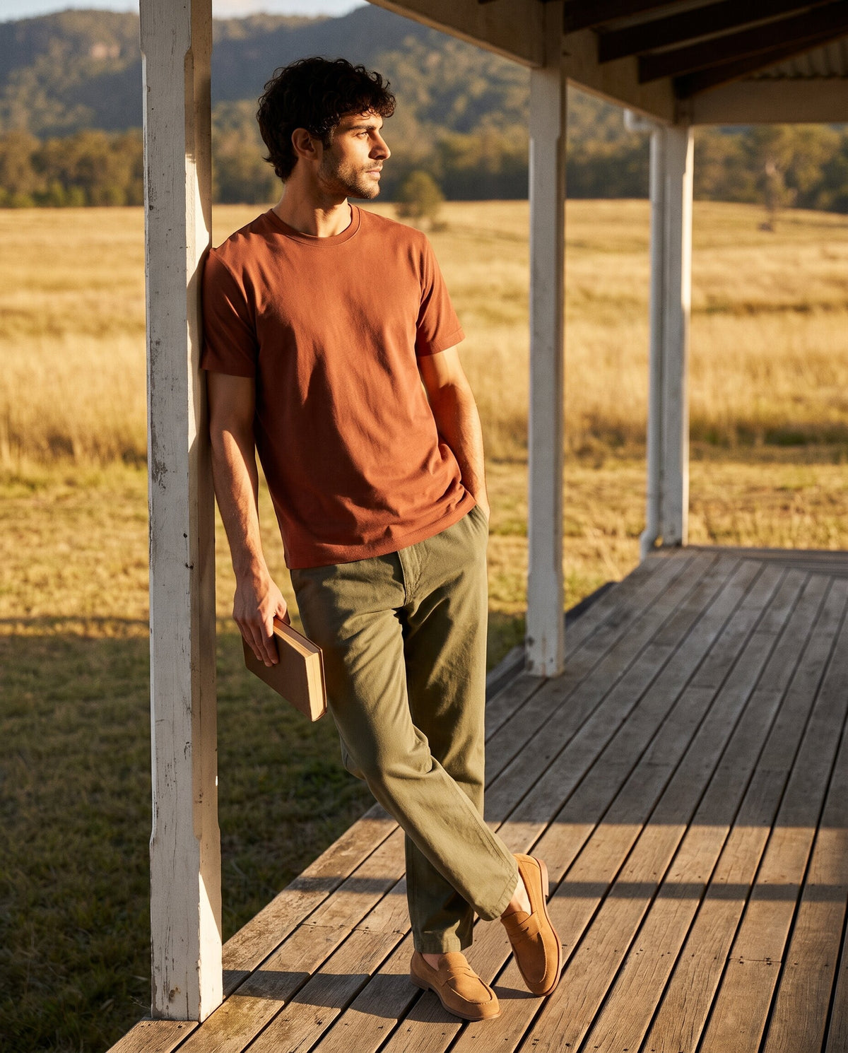 Man in Modura Sedona rust t-shirt on a lodge veranda